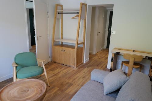 a living room with a couch and a chair and a desk at Les Gîtes d'Aillon et d'Ailleurs in Aillon-le-Jeune