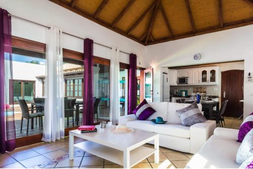 sala de estar con sofá blanco y mesa en Villa Relax Deluxe Private Pool Corralejo By Holidays Home, en Corralejo