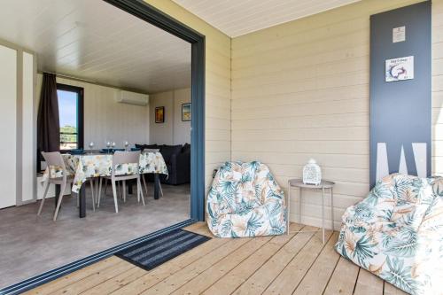 une salle à manger avec une table, des chaises et un miroir dans l'établissement D&D Cottage - Welkeys, à Saubrigues