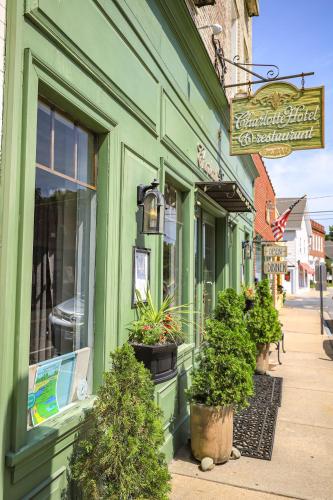 a green building with potted plants on a street at The Charlotte Hotel & Restaurant in Onancock