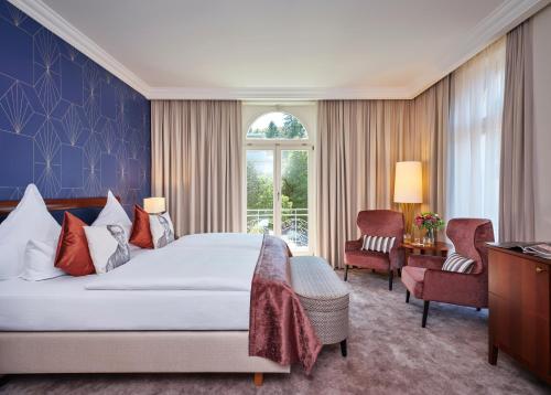 a bedroom with a large bed and a window at Maison Messmer - ein Mitglied der Hommage Luxury Hotels Collection in Baden-Baden