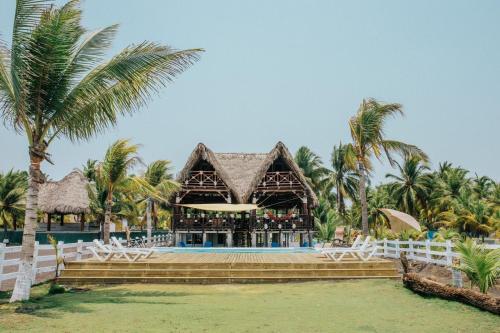 a bar at a resort with palm trees at Los Olivos La Playa Hotel y Restaurante in Escuintla
