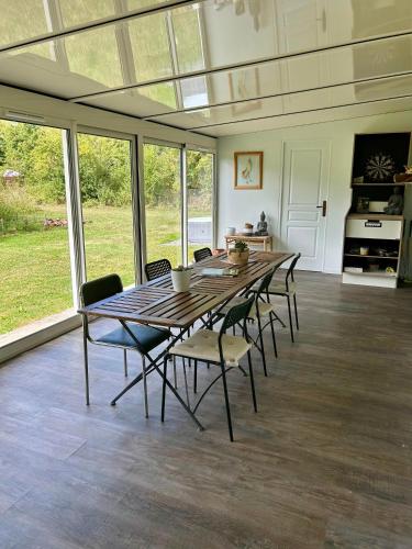 a dining room with a wooden table and chairs at la maison d'hôtes des Charentes in Les Touches-de-Périgny