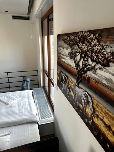 a bedroom with a painting on the wall at Luxury PENTHOUSE at the Historical Centre with free parking in Bratislava