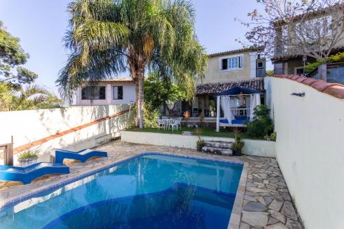 a swimming pool in front of a house at Pousada Tehau Guest House in Búzios