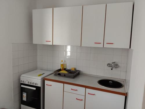 una cocina con armarios blancos y fregadero en Apartments with a parking space Orebic, Peljesac - 20250, en Orebić
