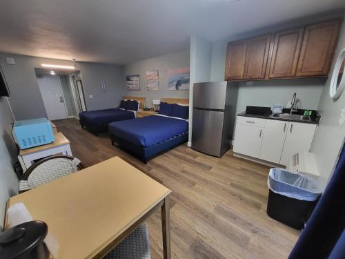 a living room with a blue couch and a kitchen at Beachside Hotel - POOL IS OPEN! in Daytona Beach