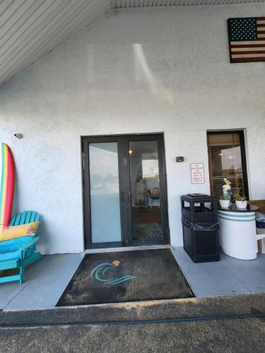 a front door of a building with a trash can at Beachside Hotel - POOL IS OPEN! in Daytona Beach