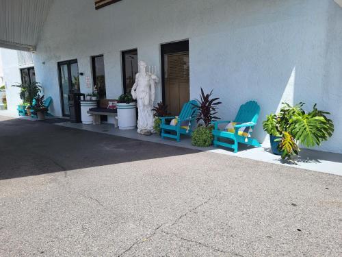 a building with chairs and a statue in front of it at Beachside Hotel - POOL IS OPEN! in Daytona Beach