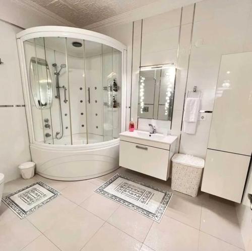 a white bathroom with a shower and a sink at Denize Sıfır 2 Yatak Odalı ve 2 Çekyatlı Bahçeli Ev - Seafront, 2 bedroom, 2 sofa bed house with big garden in Rize