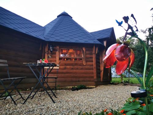 ein Blockhaus mit einem Tisch und einer roten Blume in der Unterkunft La cabane du Nuton Ardennais in Tournes