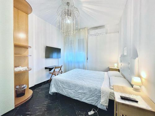 a bedroom with a bed and a desk and a chandelier at The Exquisite in Pisa