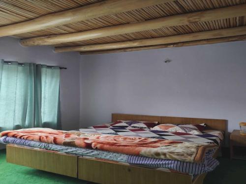 a bedroom with a bed with a wooden frame at POP HOME 81129A Skayil Guest House in Nubra