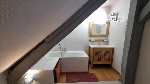 een badkamer met een wastafel en een bad bij Maison au cœur des Bois in Saint-Martin-de-Sallen