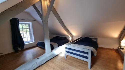 a bedroom with two beds in a attic at Maison au cœur des Bois in Saint-Martin-de-Sallen