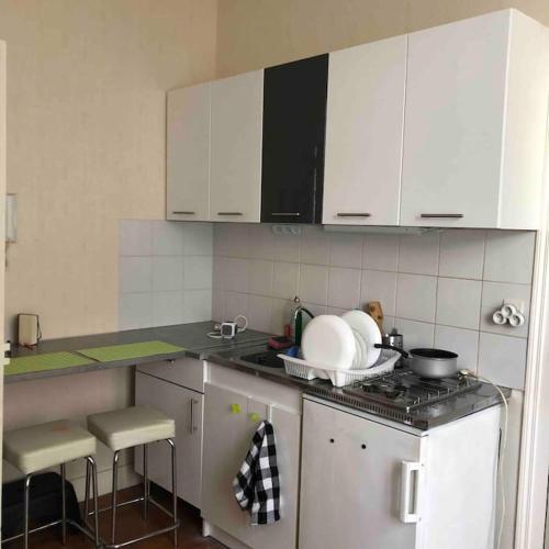 une cuisine avec des armoires blanches et un four à plaques de cuisson dans l'établissement Appt à Blois : Art et Histoire !, à Blois