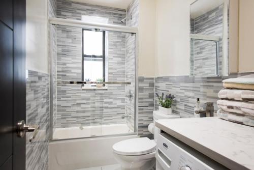 y baño con ducha, aseo y lavamanos. en 3BR in Amsterdam Ave!, en Nueva York