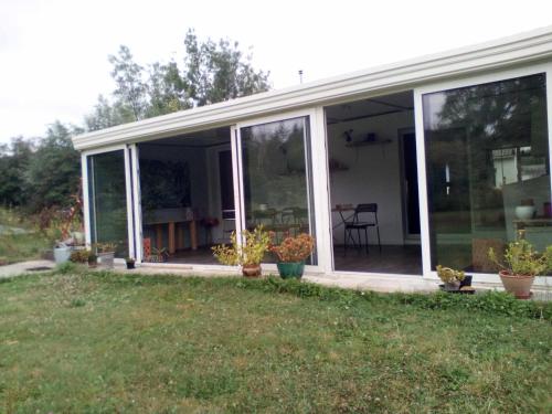 a screened in porch of a house with plants at la maison d'hôtes des Charentes in Les Touches-de-Périgny
