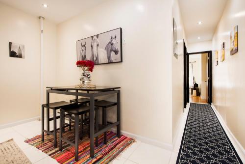 a hallway with a table and a vase of flowers on a rug at 3BR in Amsterdam Ave! in New York