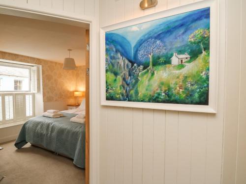 a painting hanging on a wall in a bedroom at Tan y Craig in Haverfordwest