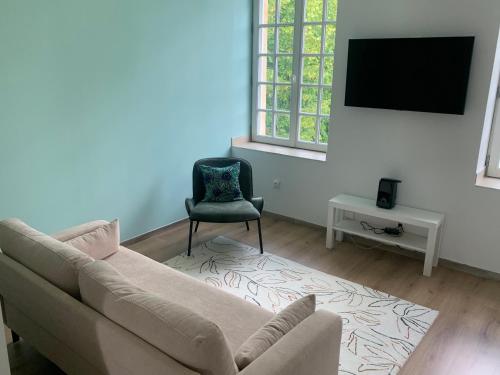 a living room with a couch and a chair at La Grand Maison in Orléans