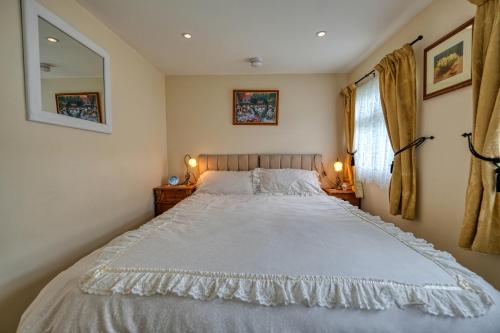 a bedroom with a large bed and two lamps at Two Hoots Chalet in Mundesley