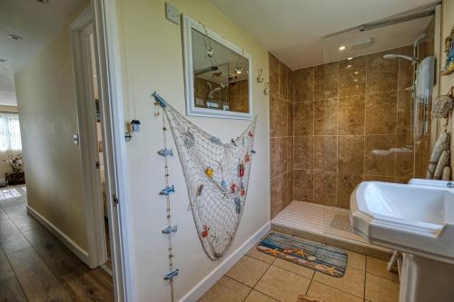 a bathroom with a shower and a sink at Two Hoots Chalet in Mundesley