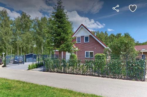 a house with a fence in front of a yard at Modern Luxury villa in Zeewolde