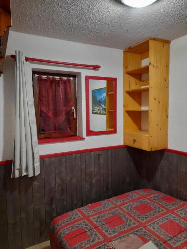 マニグードにあるAppartement au cœur des Aravisのベッドと窓のある寝室