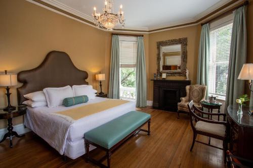 a bedroom with a bed and a desk and a mirror at Kehoe House, Historic Inns of Savannah Collection in Savannah