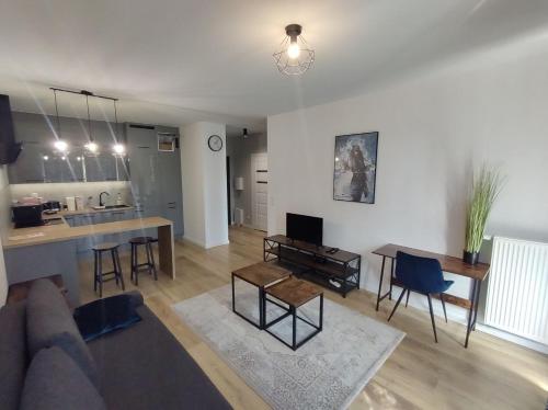 een woonkamer met een bank en een tafel en een keuken bij STARA CEGIELNIA, Faktura VAT, bezkontaktowe zameldowanie in Poznań