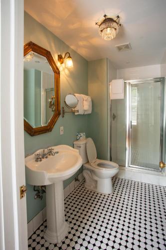 a bathroom with a sink and a toilet and a mirror at Kehoe House, Historic Inns of Savannah Collection in Savannah