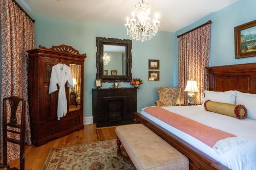 a bedroom with a large bed and a mirror at Kehoe House, Historic Inns of Savannah Collection in Savannah