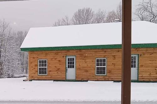 a log cabin with a green roof in the snow at 3 bed/2 bath Riverside cabin 