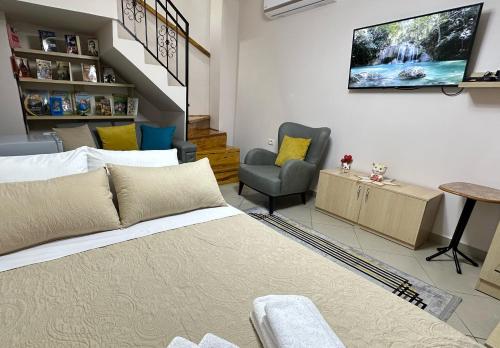 a living room with a couch and a tv on the wall at Duplex Mino, Pazari i Vjetër Korçë in Korçë