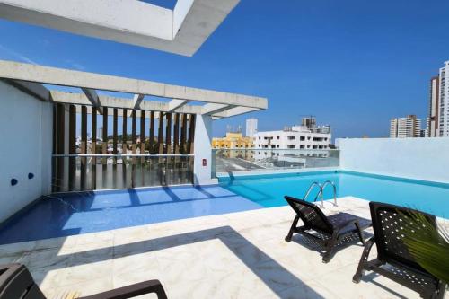 un patio con piscina y sillas en la azotea en Hermoso Apartamento Piso 17 en Cartagena Con Cercania Al Mar y Centro Historico, en Cartagena de Indias