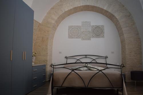 ein Schlafzimmer mit einem Torbogen und einem Bett darin in der Unterkunft FA.RÒ. DIMORA in Ruvo di Puglia