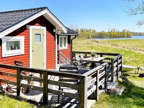 a small red building with a table and a boat at 4 person holiday home in ALVESTA-By Traum in Alvesta