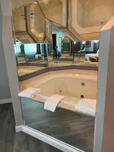 a bathroom with a tub with a large mirror at Quality Inn & Suites Red Wing in Red Wing