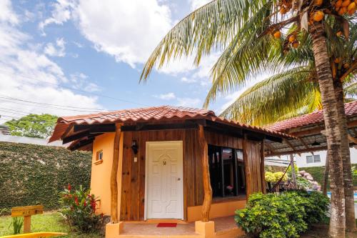 a small cabin with a door in front of a palm tree at H4 LAS CABAÑAS in Corozal