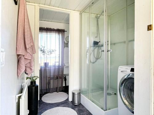 y baño con ducha y lavadora. en Holiday home ALVESTA II, en Alvesta