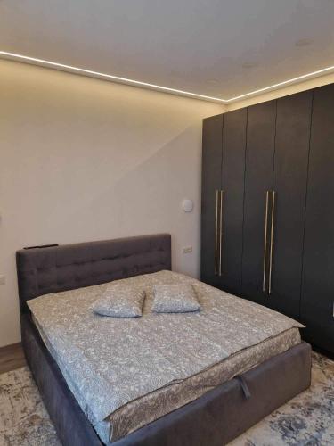 a bedroom with a bed and black cabinets at Centro apartamentai in Panevėžys