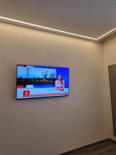 a flat screen tv hanging on a wall at Centro apartamentai in Panevėžys
