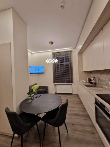 a kitchen with a table and chairs in a room at Centro apartamentai in Panevėžys