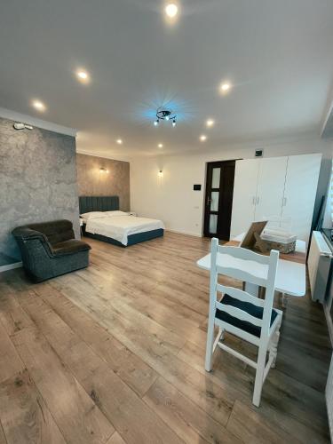 - une chambre avec un lit et une chaise dans l'établissement Studio Glen, à Târgu-Mureş