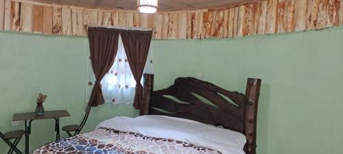 a bedroom with a bed and a window at Cozy Huts in Nyandarua 