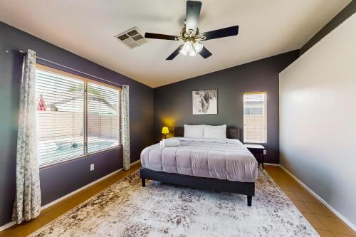 1 dormitorio con 1 cama y ventilador de techo en Blue Umbrella Retreat, en Avondale