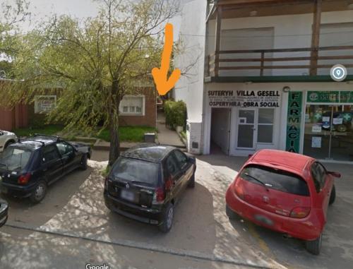 two cars parked in a parking lot in front of a building at Mono Yoly in Villa Gesell