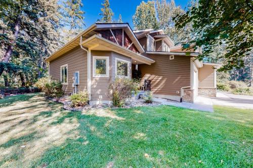 a house with a green lawn in front of it at Cedar Point Hideaway in Columbia Falls