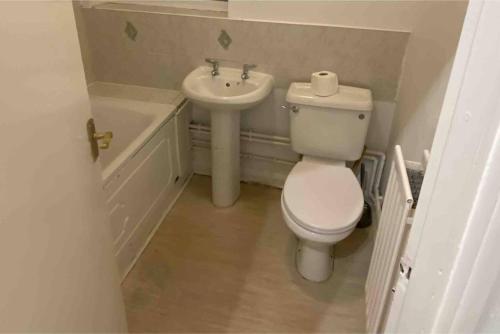 a small bathroom with a toilet and a sink at Snug Kingsize bedroom flat in London in London